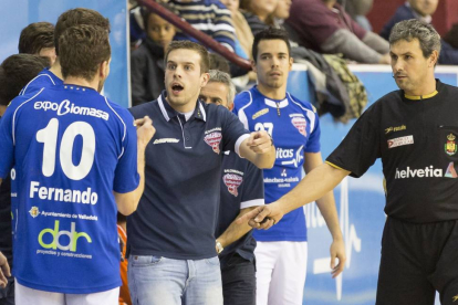 El entrendor del BM Atlético Valladolid da ordenes a Fernando en presencia del árbitro del partido-M. A. SANTOS