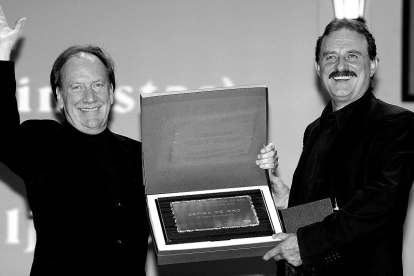El director de la película 'Los optimistas' y el actor Lazar Ristovski con la placa que acredita a la película como ganadora de la Seminci.