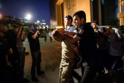 Policías turcos detienen, la noche del sábado, a unos militares del Ejército de Turquía tras el fallido golpe de Estado.-AFP / OZAN KOSE