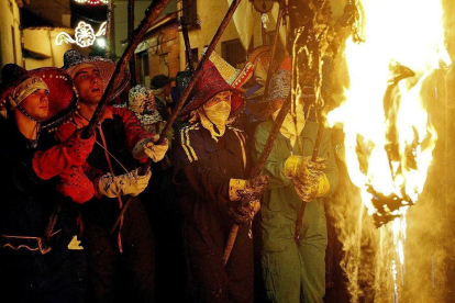 Un grupo de mayorganos portan los pellejos incandescentes en la procesión del Vítor.-J. M. LOSTAU