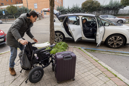 Daniel Rodríguez carga el maletero del coche ante la mirada de Rut Carpintero, en Valladolid. / P. REQUEJO (PHOTOGENIC)