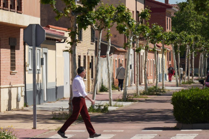 Un hombre cruza la calle Cañada Real por el paso de cebra