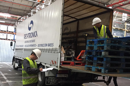 Un operario supervisa la carga y descarga de uno de los camiones de la flota de Recytronica.