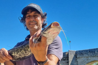 Un pescador con un siluro pescado en Simancas