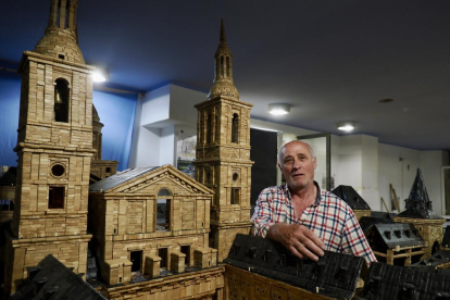 Ángel Rodríguez, en su estudio, posa junto a su maqueta de El Escorial