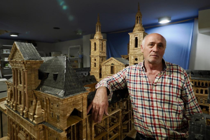 Ángel Rodríguez, en su estudio, posa junto a su maqueta de El Escorial