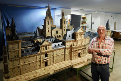 Ángel Rodríguez, en su estudio, posa junto a su maqueta de El Escorial