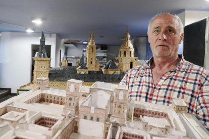 Ángel Rodríguez, en su estudio, posa junto a su maqueta de El Escorial