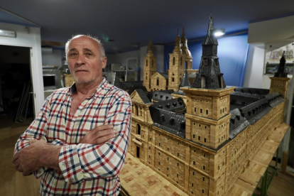 Ángel Rodríguez, en su estudio, posa junto a su maqueta de El Escorial