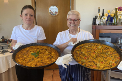 Eva Munera y Laura Fernández con dos paellas antes de servir a la mesa en el restaurante Villa Mencía en Corullón. /