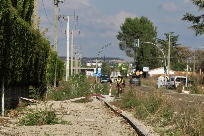 Dos ciclistas circulan por la calzada, junto a las obras inacabadas del carril bici.