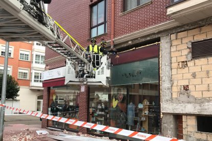 Labores de saneamiento de los bomberos de la Diputación en la fachada derrumbada.