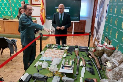 El coronel Velarde muestra al subdelegado Canales la droga y las armas incautadas.