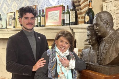 Luis, quinta generación, y su madre, Marisa Duque, posan ante el busto de bronce de los predecesores, situado en el interior del mesón segoviano.