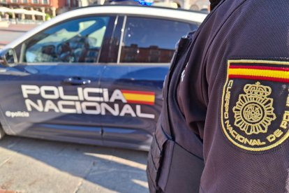 Archivo - Un agente de la Policía Nacional junto a su vehículo. Foto archivo.