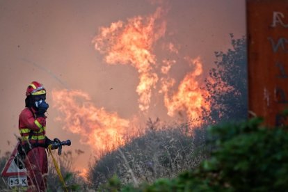 Un bombero trata de apagar el fuego, a 21 de agosto de 2025, en Anllarinos del Sil, León.