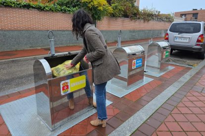 Una persona tira una bolsa de basura en un contenedor de Arroyo de la Encomienda.