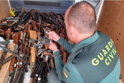 Un agente de la Guardia Civil de Valladolid con parte de las armas que se han destruido.