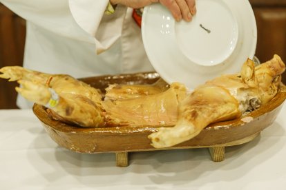 Tradicional ritual de partir el cochinillo con un plato