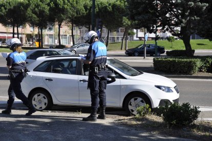 Dos policías multan a un coche parado en una calle de Valladolid.