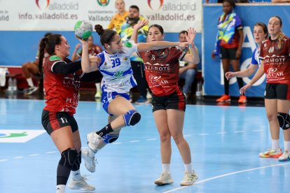 Sandra Monteagudo lanza a portería ante la oposición de dos rivales.