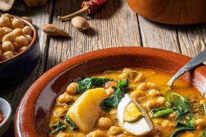 El potaje de vigilia, con garbanzos, espinacas y bacalao, es uno de los guisos más tradicionales de la Cuaresma, servido aquí con huevo cocido en plato de barro