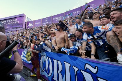 Aficionados del Deportivo abrazan a uno de sus jugadores tras el ascenso.