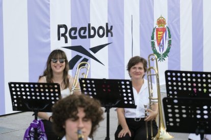 Músicos ante el panel con el escudo del club y el logo del patrocinador.
