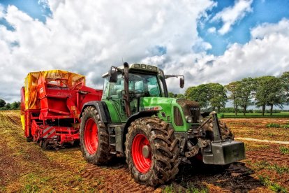 Tractor con maquinaria remolcada para arrancar cultivos de raíz