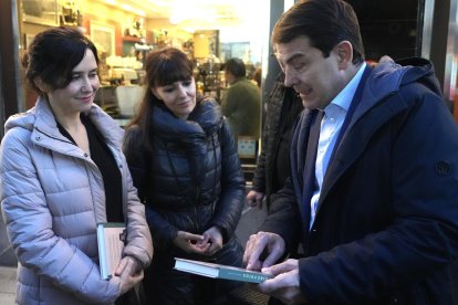 Isabel Díaz Ayuso y Alfonso Fernández Mañueco reciben el libro 'Los días fríos' de manos de su autora Pilar Mesonero, en el centro