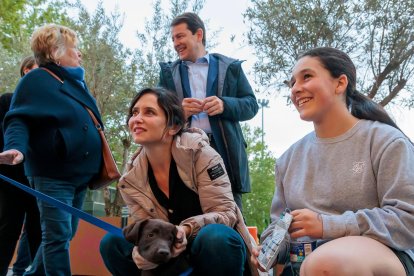 Isabel Díaz Ayuso  con un perro y su dueña en la Acera Recoletos.