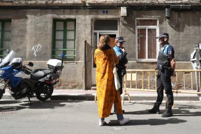 La trabajadora social del Ayuntamiento habla con dos agentes de Policía en su primera visita a los okupas
