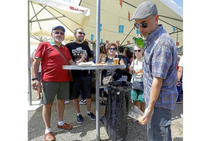 Un hombre escanciando una botella de sidra.