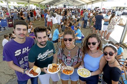Un grupo de amigos con sus raciones de las diferentes casetas de la feria.