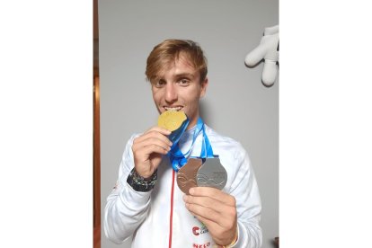 Marcos Caballero con las tres medallas, mordiendo el oro. / E. M.