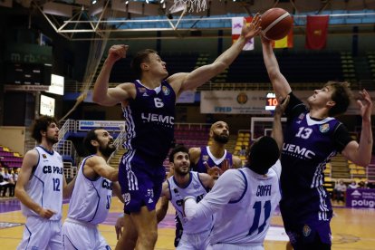 Puidet y Berg luchan por el rebote ante la mirada de varios jugadores de ambos equipos. / LOSTAU