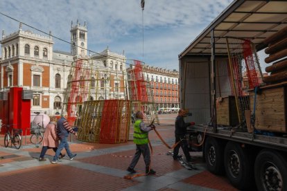 Operarios encargados de la instalación de la base del árbol de Navidad en la Plaza Mayor. -J.M. LOSTAU