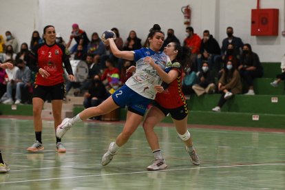 Elba Álvarez trata de lanzar, siendo agarrada por una jugadora local. / LOF