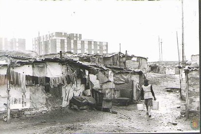 Una mujer acarrea dos cubos de agua en una zona de chabolas del barrio de San Isidro. Años 70.ARCHIVO MUNICIPAL
