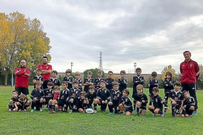 Foto de familia del equipo sub 8 posando en los campos de Pepe Rojo junto a sus entrenadores, entre ellos Alvar Enciso.