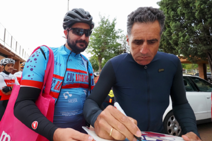 Miguel Indurain firma el maillot a uno de los participantes en la marcha. / PHOTOGENIC