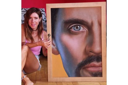 Laura Serrano con el cuadro de Paco León. Exposición de 'rostros de cine' de Laura Serrano.  / E. M.