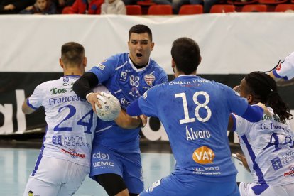 Darko Dimitrievski frenado por el italiano Franceschetti ante la mirada de Álvaro Martínez en el pivote. / PHOTOGENIC