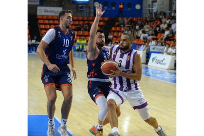 Mike Torres intenta superar la defensa de un jugador del Tizona. / TOMÁS ALONSO