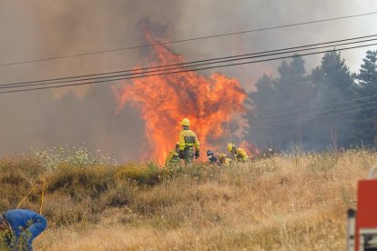 Efectivos de los bomberos de Segovia, de la Junta de Castilla y León y Protección Civil trabajan en la extinción del incendio en la Nacional-110.- ICAL