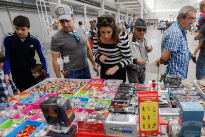 Asistentes observan todas las figuras a la venta de la Feria del Coleccionismo. -J.M. LOSTAU