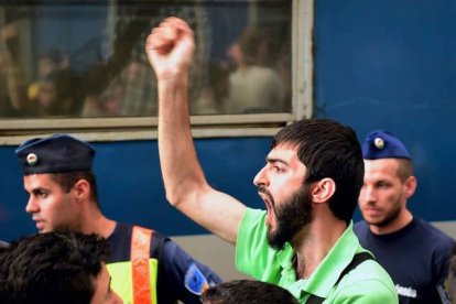 AFP / ATTILA KISBENEDEK 

Miles de refugiados protestan enfurecidos delante de la estación de trenes de Keleti después de que las autoridades húngaras les blindaran la entrada este martes.