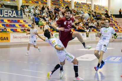 Álvaro Martínez lanza con la oposición del jugador de Antequera. / LOF