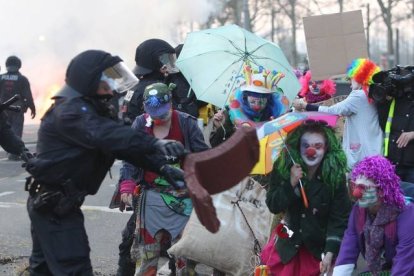 Manifestantes vestidos de payasos se encaran a varios agentes. DANIEL ROLAND | AFP