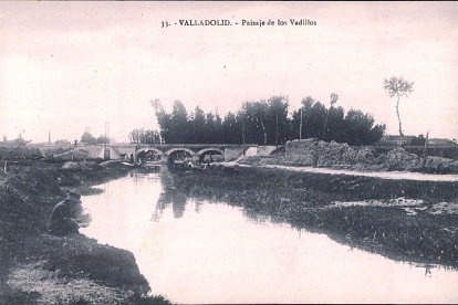 La Esgueva en Vadillos, en la primera década del siglo XX. Al fondo se ve el mismo puente que hoy permite el paso de las vías sobre río en Paseo del Cauce. En primer término se aprecia una persona pescando y al lado del puente un grupo de lavanderas. ARCHIVO MUNICIPAL